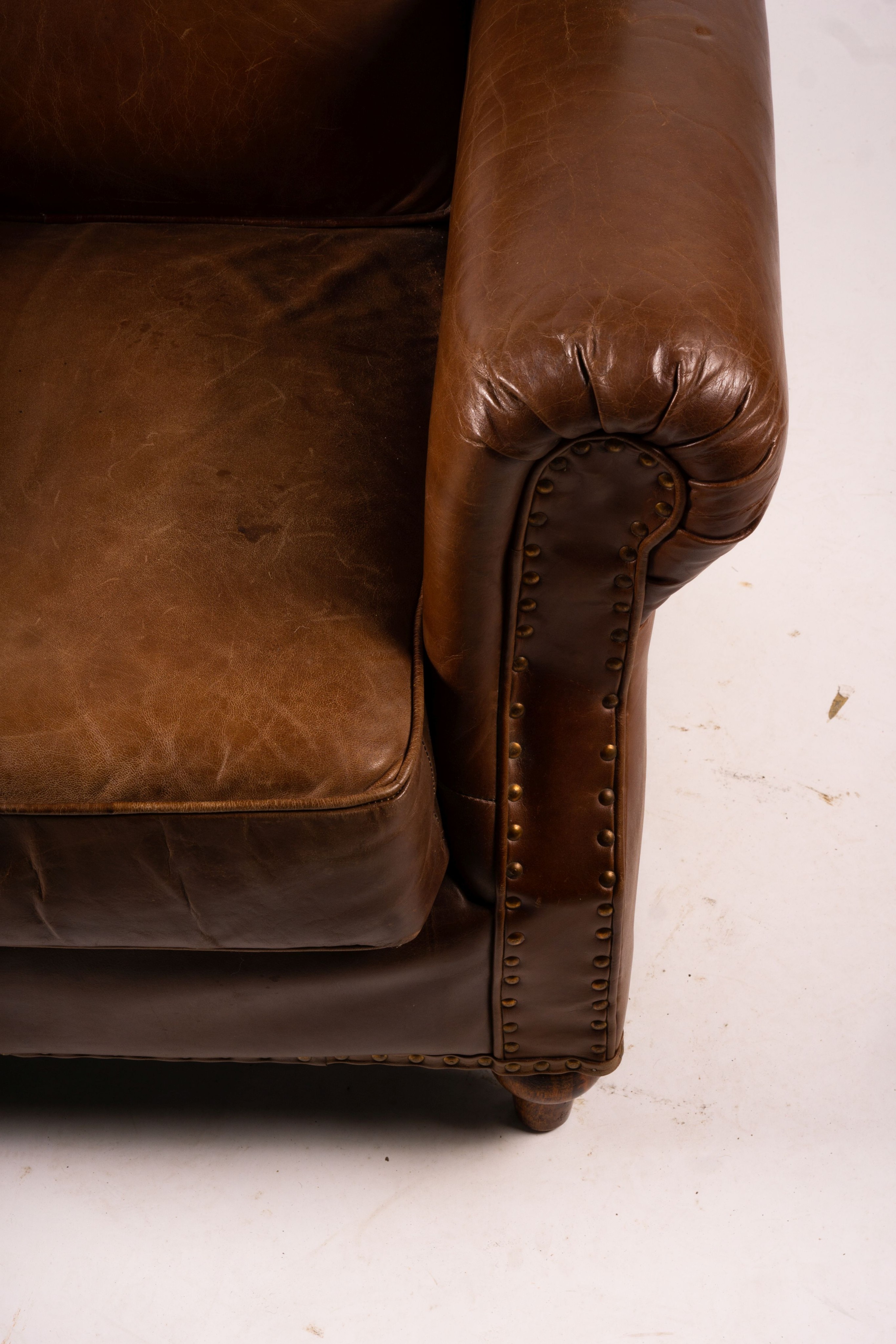 A pair of brown leather club armchairs, width 96cm, depth 80cm, height 90cm